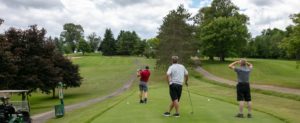 Three men playing golf