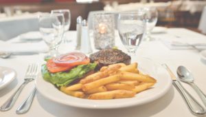 Hamburger and fries on a dining plate.