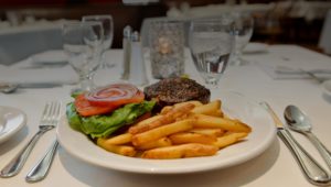 Hamburger and fries on a dining plate.